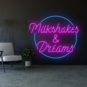 May include: Pink neon sign with a blue circle around it that says "Milkshakes & Dreams".