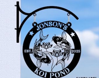 Może przedstawiać: Czarny metalowy znak stawu koi z napisem "Jonson's Koi Pond EST. 2025". Znak przedstawia dwie ryby koi i kwiaty lotosu w okrągłej ramie, zawieszone na czarnym metalowym wsporniku.