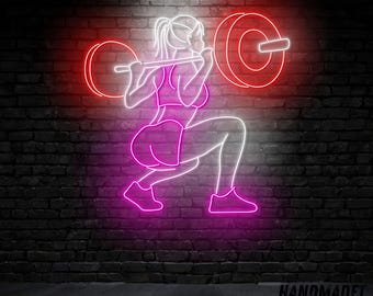 Può includere: Un cartello al neon che raffigura una persona che fa uno squat con un bilanciere. Il cartello è rosa e bianco e ha il testo "HANDMADET NEON" in basso.
