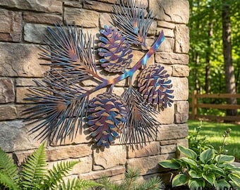 May include: A metal wall art piece featuring a pine branch with three pinecones and long needles. The metal has a heat-treated finish with iridescent blue, purple, and copper tones, creating a gradient effect across the textured surface.
