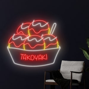 May include: A neon sign depicting a bowl of takoyaki, a Japanese street food. The sign is white with red and yellow accents. The text "TAKOYAKI" is written in white neon letters.
