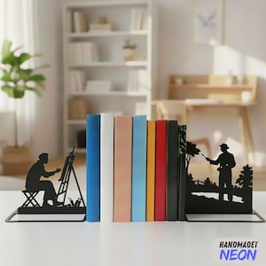 May include: Black metal bookends with artist silhouettes, holding books of various colors. The bookends feature an artist painting and a figure in a landscape. The word "HANDMADET NEON" is in the bottom right corner.