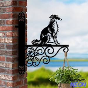 May include: Black metal silhouette of a dog sitting on a decorative scrollwork bracket. The bracket is mounted to a brick wall. A hanging plant is visible in the foreground.