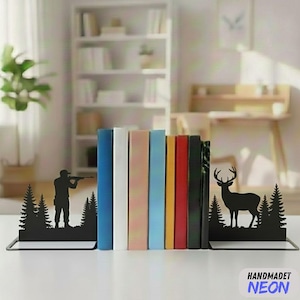 May include: Black metal bookends featuring a hunter and a deer silhouette. The bookends support a row of colourful books. The bookends are on a white surface. The bookends are a decorative item.