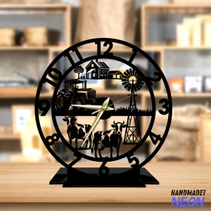 Könnte beinhalten: Schwarze Metalluhr mit einer Farmkulisse, darunter ein Traktor, Kühe, eine Windmühle und ein Haus. Das Zifferblatt der Uhr hat römische Ziffern und goldene Zeiger.