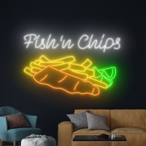 Op de afbeelding: Neon-bord met de tekst "Fish'n Chips" in wit, met een gele vis en friet in een witte papieren zak en een groene limoenwig.