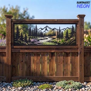 Peut inclure: Un panneau rectangulaire en métal noir présentant une silhouette découpée au laser d'une chaîne de montagnes, d'une forêt de pins et d'une rivière sinueuse. Le panneau décoratif est monté horizontalement dans un cadre de clôture en bois brun.
