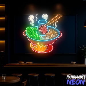 May include: A neon sign depicting a steaming pot of food with chopsticks, vegetables, and meat. The sign is outlined in bright colors, including red, orange, green, and blue. The sign is mounted on a dark wall above a wooden bar with stools. The text "HANDMADET NEON" is at the bottom.