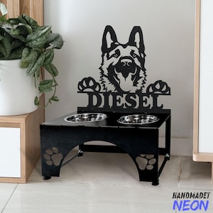 May include: Black metal dog bowl stand with a German Shepherd silhouette and the name "Diesel" on the front. The stand has two bowls and paw print cutouts.