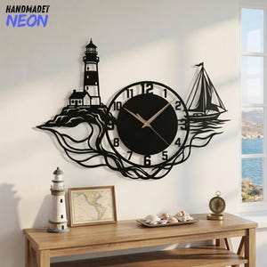 May include: A black metal wall clock featuring a lighthouse on the left and a sailboat on the right, connected by stylized wave patterns. The clock face has gold-colored hands and black numbers. The text HANDMADET NEON appears in the top left corner.