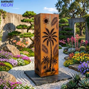 Puede incluir: Una escultura de jardín rectangular de metal envejecido con siluetas de palmeras y un diseño de sol. La escultura está sobre una base de piedra gris oscuro, rodeada de un exuberante jardín con flores y vegetación coloridas. El texto "HANDMADET NEON" es visible.