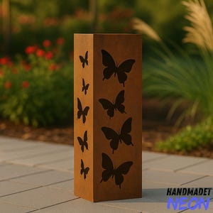 May include: A rectangular, brown metal garden sculpture with cut-out butterfly designs. The sculpture has a weathered appearance and stands on a paved surface. The word "HANDMADET" and the word "NEON" are printed on the bottom right corner.