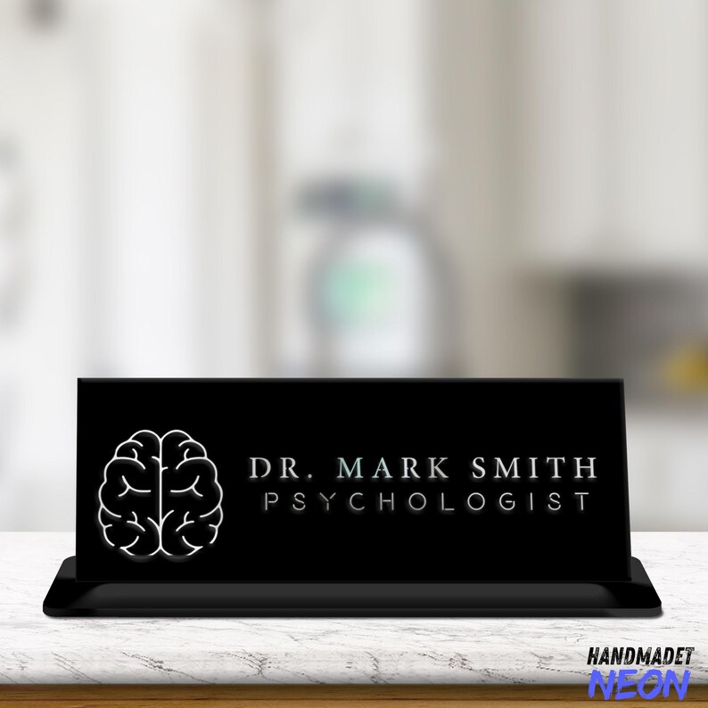 May include: Black desk sign with a white brain outline and the text "DR. MARK SMITH PSYCHOLOGIST".