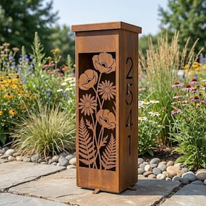 Puede incluir: Un letrero de número de casa alto, rectangular y de metal color óxido con un diseño cortado con láser de amapolas, margaritas y helechos en el panel frontal. El panel lateral vertical muestra los números de casa 2541 en un corte.