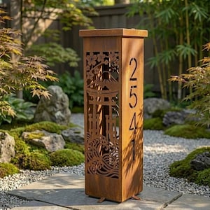 Puede incluir: Un poste de dirección rectangular y alto de metal color óxido con diseños cortados con láser de una puerta torii, el monte Fuji, flores de cerezo y olas del mar. El lado vertical muestra los números de casa 2541 en una fuente moderna.