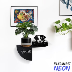 May include: Black wall shelf with a dog silhouette, a potted plant, and the word "Spark" written on the shelf. The shelf is mounted on a white wall.
