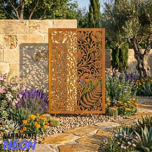 Op de afbeelding: Een decoratief, rechthoekig, roestbruin metalen tuinscherm met een bloemenontwerp. Het scherm staat in een tuin met diverse planten en bloemen. Het scherm wordt ondersteund door metalen poten.