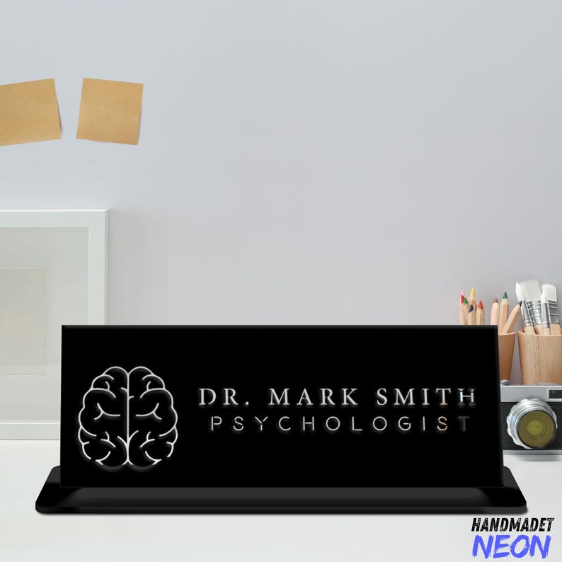 May include: Black desk sign with a white brain graphic and the text "DR. MARK SMITH PSYCHOLOGIST".