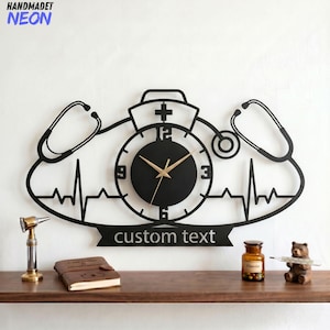May include: Black metal wall clock with a medical theme. The clock features a nurse's hat, stethoscope, and a heartbeat line design. The clock face is black with gold hands, and the text "custom text" is displayed below.