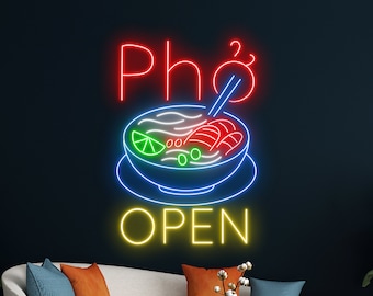 May include: Neon sign with the words "Pho" and "Open" in a bowl of pho with chopsticks. The sign is yellow, red, blue, and green.