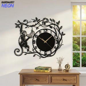 May include: A black wall clock featuring a monkey hanging from a vine and holding a bunch of bananas. The clock face is circular with black numbers on a white background and gold-colored hands. The design is surrounded by black metal vines.