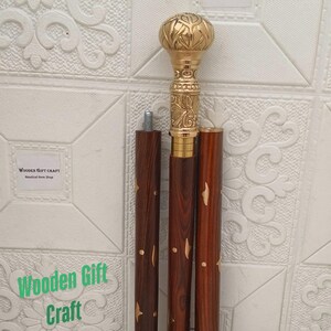 Könnte beinhalten: Zerlegte Spazierstock mit einem goldfarbenen, verzierten Griff und einem dunkelbraunen Holzschaft. Der Griff weist ein detailliertes Blumendesign auf. Die Worte "Wooden Gift Craft" sind im Bild zu sehen.