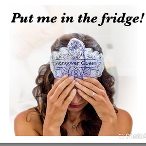 May include: A woman wearing a silver glitter crown with the text "Hangover Queen" on it. She is holding her hands over her face, looking down.
