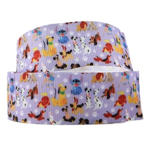 May include: Purple ribbon with a repeating pattern of cartoon dogs, including Dalmatians, a brown and white dog, and a blue dog with a single ear. The ribbon has a white background with paw prints.