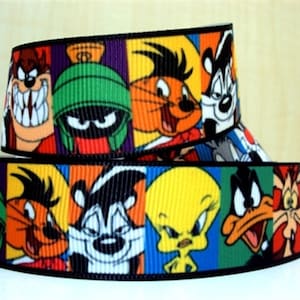 May include: A colourful ribbon featuring cartoon characters from the Looney Tunes franchise. The ribbon features Bugs Bunny, Daffy Duck, Tweety Bird, Sylvester the Cat, Porky Pig, and Road Runner.