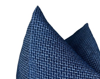 Puede incluir: Primer plano de una almohada azul con estampado y textura tejida. La almohada está hecha de una tela suave y lujosa.