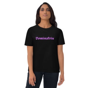 May include: A black t-shirt with a purple "Dominatrix" graphic printed on the front.