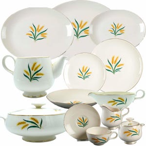 Puede incluir: Un juego de vajilla de cerámica blanca con ribete dorado y diseño de trigo. El juego incluye una tetera, jarra de crema, azucarero, tazón para servir, platos y tazas.