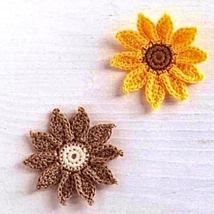May include: Two crocheted sunflower-shaped flowers. One flower is brown with a white center, and the other is yellow with a brown center.