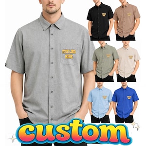 May include: A gray short-sleeve button-down shirt with a pocket that says "YOUR LOGO HERE." Additional shirts in black, brown, green, beige, light blue, and blue are also shown. The word "custom" is at the bottom.