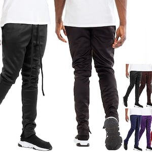 May include: Black track pants with a drawstring waist and ankle zippers. The pants are shown in multiple colors, including black, brown, gray, and beige. The pants have a slim fit and are made of a smooth material.