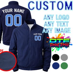May include: Navy blue custom jacket with the text "YOUR NAME" and the number "00" in light blue. The jacket has a full zipper and a white interior. The image also includes the text "CUSTOM", "ANY LOGO ANY TEXT ANY IMAGE", and the "DTF Print Pros" logo.