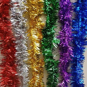 Puede incluir: Surtido de guirnaldas de lamé metálico de colores en rojo, plata, oro, verde, morado y azul. La guirnalda está hecha de tiras finas y brillantes de papel de aluminio.