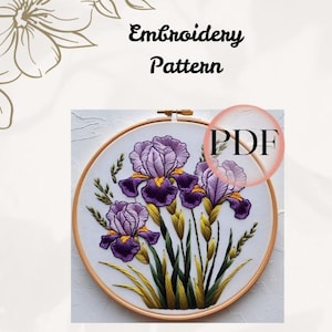 Puede incluir: Un patrón de bordado con flores de iris moradas con detalles amarillos, presentado en un bastidor de bordado de madera. El texto "Embroidery Pattern" está encima del bastidor, y un gráfico "PDF" está superpuesto.