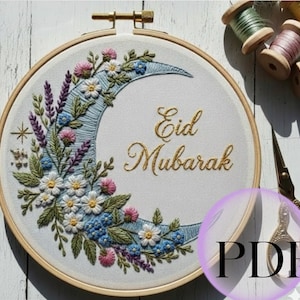 Può includere: Ricamo su telaio con un design a mezzaluna e dettagli floreali in bianco, rosa, blu e verde. Le parole "Eid Mubarak" sono ricamate con filo d'oro. Il telaio è in legno.