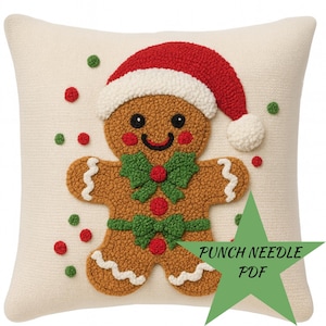May include: Cream-colored square throw pillow featuring a gingerbread man design. The gingerbread man wears a red Santa hat and a green bow tie. Red and green decorative dots are scattered around the gingerbread man. The text "PUNCH NEEDLE PDF" is in a green star.