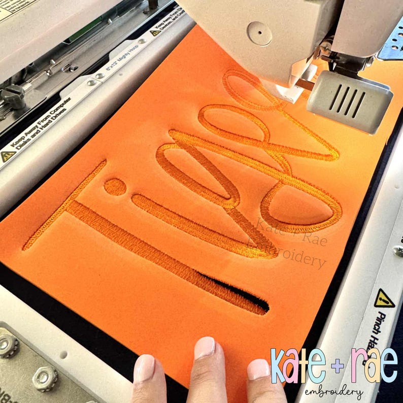 Puede incluir: Una tela naranja con la palabra "TIPS" bordada con hilo dorado por una m&aacute;quina. El texto "kate + rae embroidery" es visible en la esquina inferior derecha.