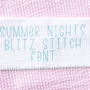 May include: White fabric with the text "SUMMER NIGHTS BLITZ STITCH FONT" embroidered in teal blue thread.