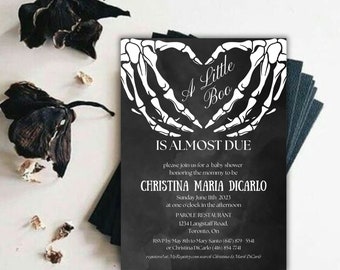 Könnte beinhalten: Eine schwarz-weiße Babyparty-Einladung mit einem Skelett-Hand-Herz-Design. Der Text lautet "A Little Boo is Almost Due" und enthält den Namen Christina Maria DiCarlo, das Datum und die Uhrzeit der Party sowie den Ort.