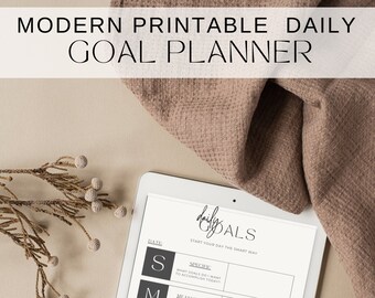 May include: A white tablet with a daily goals planner on the screen. The planner is organized using the SMART method: Specific, Measurable, Achievable, Relevant, and Time-Bound.