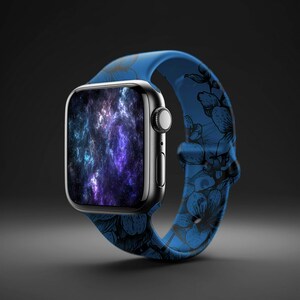 May include: A blue Apple Watch with a floral print band. The watch face displays a galaxy-like image with purple, blue, and white colors.
