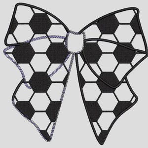 May include: A decorative bow featuring a soccer ball pattern. The bow is black and white with a repeating hexagonal design, outlined in black. The edges are finished with a purple stitch.