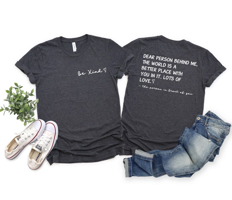 May include: Two heather grey t-shirts with a matching design. The front of one shirt says "Be Kind" with a heart symbol. The back of the other shirt says "Dear person behind me, the world is a better place with you in it. Lots of love. - the person in front of you".