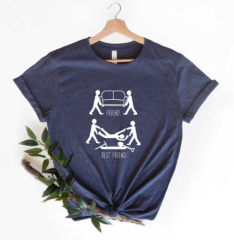 May include: A navy blue t-shirt with a white graphic of two stick figures carrying a couch, labeled "FRIEND." Below that, two stick figures are carrying another stick figure, labeled "BEST FRIEND."
