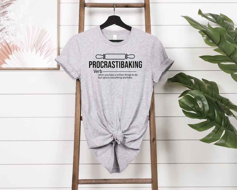 May include: Grey t-shirt with a black graphic that says "PROCRASTIBAKING" and defines it as a verb: "when you have a million things to do but ignore everything and bake."