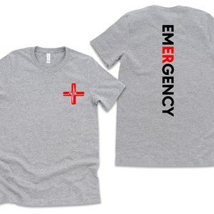May include: Gray t-shirt with a red medical cross on the front and the word "EMERGENCY" in black letters down the back.